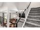 Modern staircase with metal railings leading to a cozy living room with stylish furnishings at 12908 Hudson St, Thornton, CO 80241