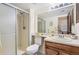 Bright bathroom with a glass-enclosed shower, a wood vanity with ample counter space, and a large mirror at 18064 E Ohio Ave # 103, Aurora, CO 80017