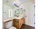 Bright bathroom with a wood vanity, neutral countertops, and large mirror at 20112 E Grand Pl, Aurora, CO 80015