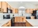 Stylish kitchen featuring white countertops, oak cabinets, and black appliances at 20112 E Grand Pl, Aurora, CO 80015