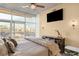 Bright main bedroom with floor to ceiling window and a mounted flat screen TV at 1700 Bassett St # 2216, Denver, CO 80202