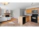 Open kitchen with stainless steel appliances, wooden cabinets, and a breakfast bar blends seamlessly with the living area at 3339 Blue Grass Cir, Castle Rock, CO 80109