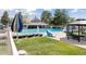 Community pool with lounge chairs and umbrella, surrounded by a grassy lawn at 17611 Hoyt Pl, Parker, CO 80134