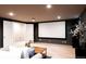 Finished basement features a large projector screen and neutral decor at 3004 S Niagara Way, Denver, CO 80224