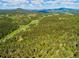Gorgeous aerial shot of tree-covered hills and mountains in a lush, green landscape at 20951 Pleasant Park Rd, Conifer, CO 80433