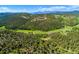 Expansive aerial view of rolling hills, dense forests, and a winding road through the countryside at 20951 Pleasant Park Rd, Conifer, CO 80433