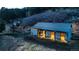 Well-maintained barn with stalls, lit up at night with horses in the landscape at 20951 Pleasant Park Rd, Conifer, CO 80433
