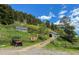 A beautiful property featuring multiple outbuildings and stunning mountain views in the background at 20951 Pleasant Park Rd, Conifer, CO 80433