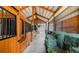 Well-lit horse barn interior with stalls and hay bales at 20951 Pleasant Park Rd, Conifer, CO 80433