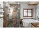 Spa bathroom featuring a glass enclosed shower, soaking tub and custom stone tile at 20951 Pleasant Park Rd, Conifer, CO 80433