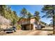 Spacious two-story home with a balcony and multiple garages nestled in the woods at 20951 Pleasant Park Rd, Conifer, CO 80433