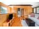 Cozy living room with hardwood floors, wood-paneled walls, and an open doorway at 20951 Pleasant Park Rd, Conifer, CO 80433