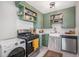 Updated kitchen with green cabinets, farmhouse sink, and stainless steel appliances at 1280 Macon St, Aurora, CO 80010