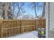 Fenced backyard with snow-covered patio and mature trees providing privacy at 8356 W 87Th Dr # A, Arvada, CO 80005