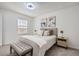 Bright bedroom with a large window, neutral tones, and a cozy seating bench at the foot of the bed at 8356 W 87Th Dr # A, Arvada, CO 80005