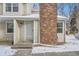 Exterior front entrance with brick chimney and inviting front door at 8356 W 87Th Dr # A, Arvada, CO 80005