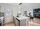 Modern kitchen featuring white countertops, stainless steel appliances, and open floor plan leading to the living room at 8356 W 87Th Dr # A, Arvada, CO 80005