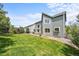 Spacious backyard with lush green lawn, mature trees, and a cozy patio area at 10802 W Indore Dr, Littleton, CO 80127