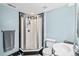 Modern bathroom with a stand up shower with black and white tiles, bright lighting, and a stylish sink at 10802 W Indore Dr, Littleton, CO 80127