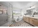 Bright bathroom featuring a glass shower, tub, and vanity with gold fixtures and patterned tile flooring at 10802 W Indore Dr, Littleton, CO 80127