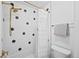 Bright bathroom featuring a tub with a shower curtain and toilet at 10802 W Indore Dr, Littleton, CO 80127