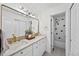 Bright bathroom featuring a double vanity with gold fixtures and a shower tub at 10802 W Indore Dr, Littleton, CO 80127