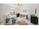 Bright bedroom with lots of sunlight and a chair with a matching ottoman at 10802 W Indore Dr, Littleton, CO 80127