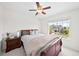 Bright bedroom with a bed and a window looking out to a house and mature landscaping at 10802 W Indore Dr, Littleton, CO 80127