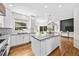 Modern kitchen with white cabinetry, stainless appliances, island, and hardwood flooring at 10802 W Indore Dr, Littleton, CO 80127