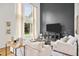 Bright living room features a soaring ceiling, large windows, and comfortable seating at 10802 W Indore Dr, Littleton, CO 80127