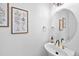 Stylish powder room featuring a vessel sink, round mirror, and decorative artwork at 10802 W Indore Dr, Littleton, CO 80127