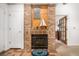 Interior view of a fireplace highlighting the brick surround and the natural light that fills the space at 9400 E Iliff Ave # 88, Denver, CO 80231