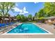 Community pool with lounge chairs surrounded by mature trees and beautiful landscaping on a sunny day at 9400 E Iliff Ave # 88, Denver, CO 80231