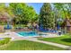 Community pool with lounge chairs and tables, surrounded by well-maintained green spaces and mature trees at 9400 E Iliff Ave # 88, Denver, CO 80231
