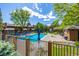 Pool view with lounge chairs and tables, surrounded by well-maintained green spaces and mature trees at 9400 E Iliff Ave # 88, Denver, CO 80231