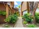 Inviting walkway nestled between buildings, lined with lush greenery and colorful hanging plants at 9400 E Iliff Ave # 88, Denver, CO 80231