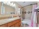 Bathroom featuring granite countertops, honey oak cabinets, and a shower-tub combo at 5809 S Pearl St, Centennial, CO 80121