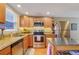 A modern kitchen with stainless steel appliances, light wood cabinets, and granite countertops at 5809 S Pearl St, Centennial, CO 80121