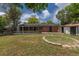 Spacious backyard featuring a brick home, covered patio, storage shed and circular stone detail at 6176 Ammons St, Arvada, CO 80004
