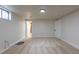 Finished basement with carpet, a door leading to another room, and a nearby window at 6176 Ammons St, Arvada, CO 80004