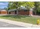 Quaint brick home with a neat lawn and mature tree at 6176 Ammons St, Arvada, CO 80004