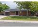 Charming brick home features a well-maintained front yard and attached garage at 6176 Ammons St, Arvada, CO 80004