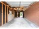 Large two-car garage with exposed brick and unfinished ceiling at 6176 Ammons St, Arvada, CO 80004