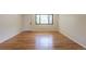 Cozy living room with hardwood floors, large window, and a white door at 6176 Ammons St, Arvada, CO 80004