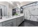 A spacious bathroom features black and white tiling, dual vanity, and glass shower at 17860 Calendula Dr, Parker, CO 80134