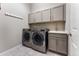 A functional laundry room with modern washer and dryer units and ample storage space at 17860 Calendula Dr, Parker, CO 80134