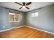 Well-lit bedroom features hardwood floors, ceiling fan, and view to brick fireplace at 4780 E Montana Pl, Denver, CO 80222