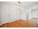 Bright dining area showcasing hardwood floors and a stylish light fixture with adjacent door at 4780 E Montana Pl, Denver, CO 80222