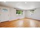 Inviting living room with gleaming hardwood floors, large windows, and a freshly painted white door at 4780 E Montana Pl, Denver, CO 80222