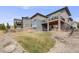 Spacious backyard with lush greenery, a stone wall, and a patio area for outdoor enjoyment at 817 Backcountry Ln, Highlands Ranch, CO 80126